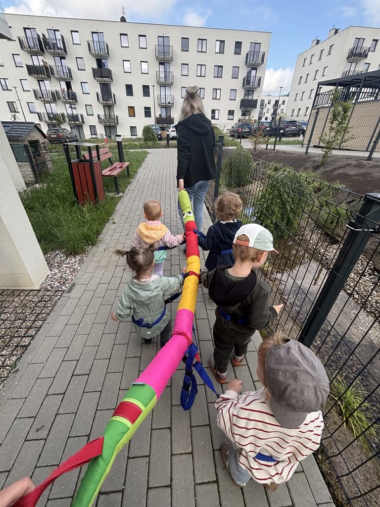 Grupa dzieci na spacerze z kolorową gąsienicą